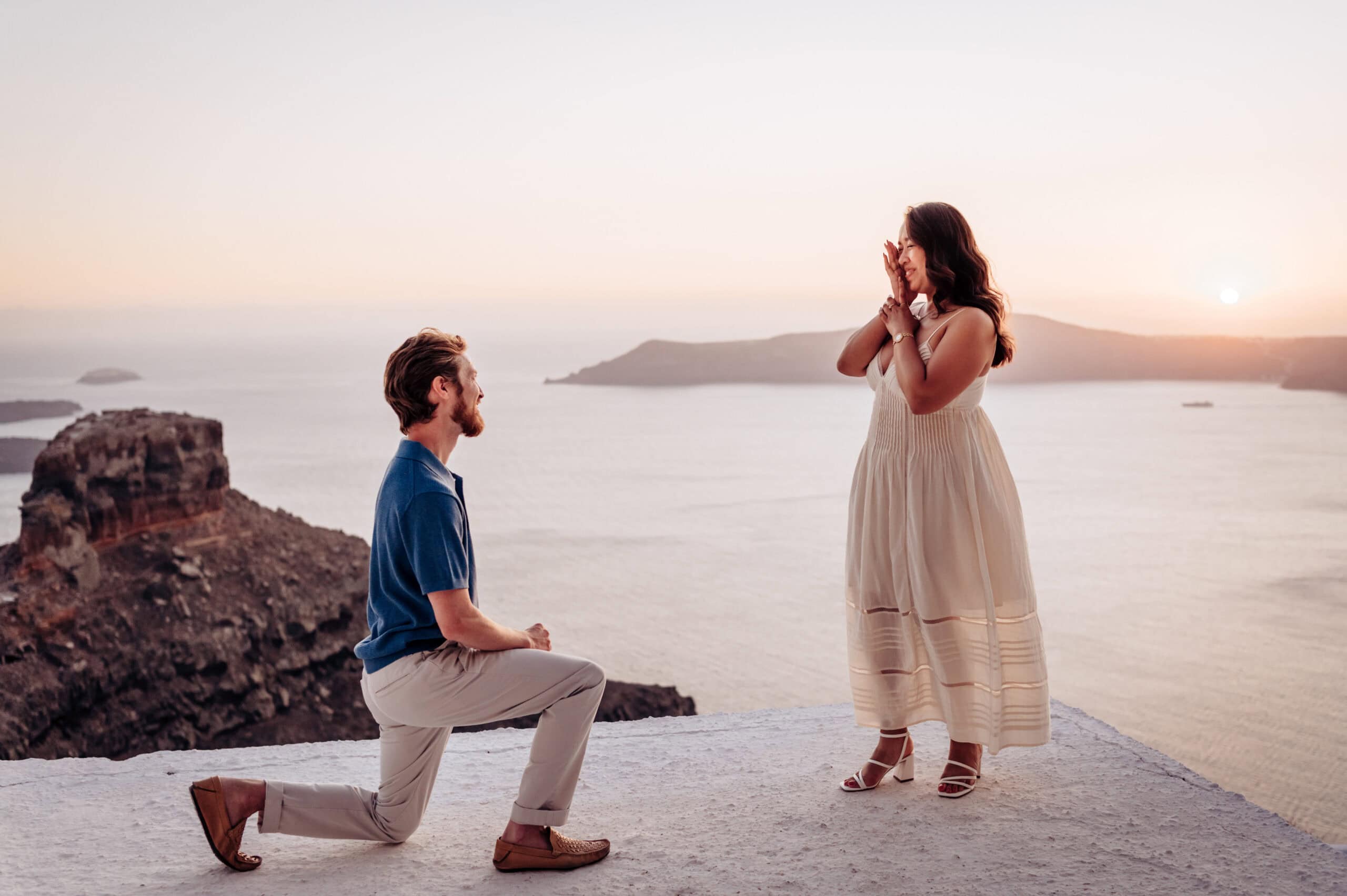 Surprise proposal overlooking the Santorini caldera at sunset